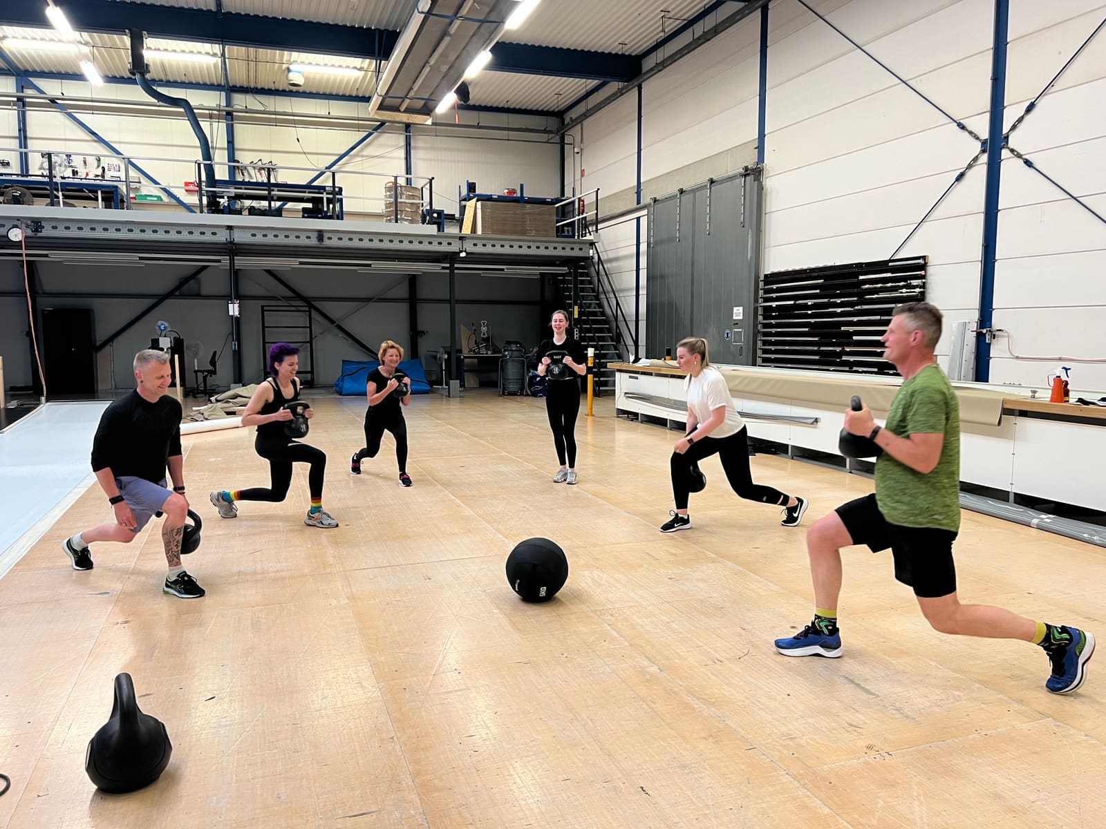Teamtraining met kettlebells in een bedrijfshal